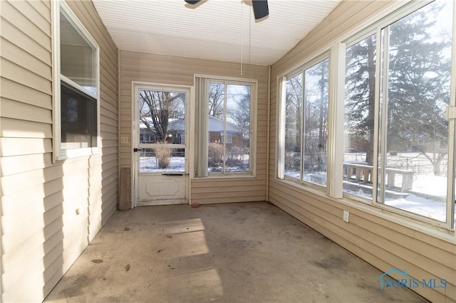 unfurnished sunroom with ceiling fan