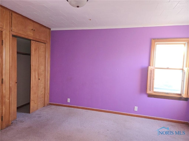 unfurnished bedroom featuring crown molding and light carpet