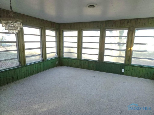 unfurnished sunroom featuring an inviting chandelier