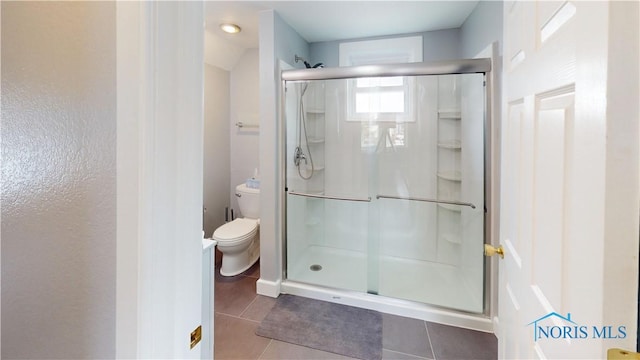 bathroom with toilet, tile patterned flooring, and walk in shower