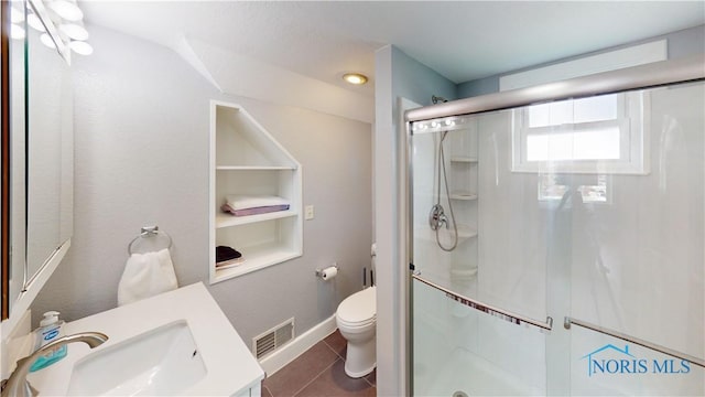 bathroom with tile patterned flooring, a shower with door, vanity, toilet, and built in features