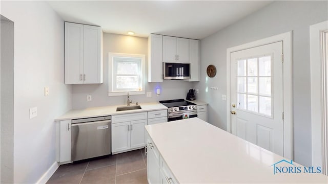 kitchen featuring plenty of natural light, appliances with stainless steel finishes, white cabinetry, and sink