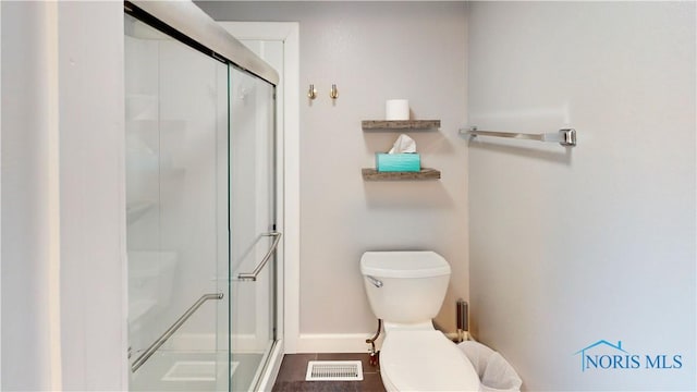 bathroom with toilet and a shower with door