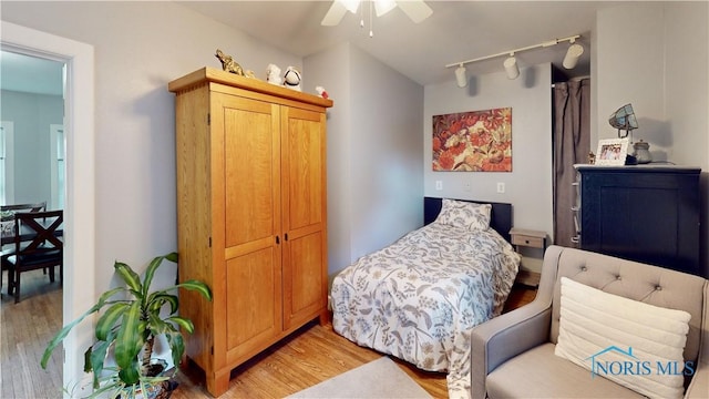 bedroom with ceiling fan, a closet, track lighting, and light hardwood / wood-style flooring