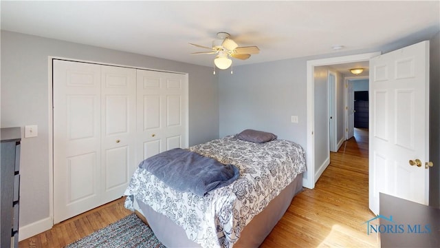 bedroom with ceiling fan, a closet, and light hardwood / wood-style floors