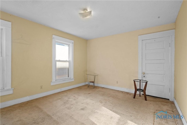 unfurnished room featuring light carpet