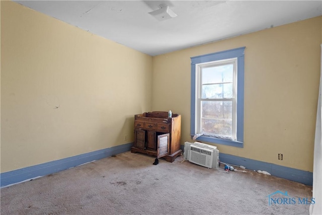 unfurnished room with a wall mounted AC and light carpet