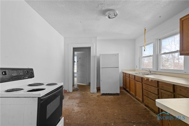 kitchen featuring white refrigerator, electric range, a textured ceiling, and sink