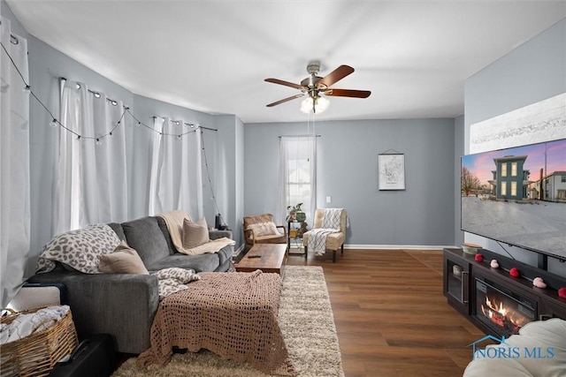 living room with dark hardwood / wood-style flooring and ceiling fan