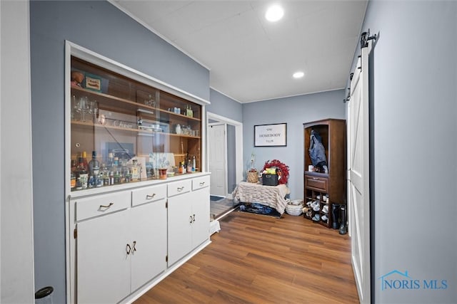 interior space with hardwood / wood-style flooring, white cabinetry, and a barn door