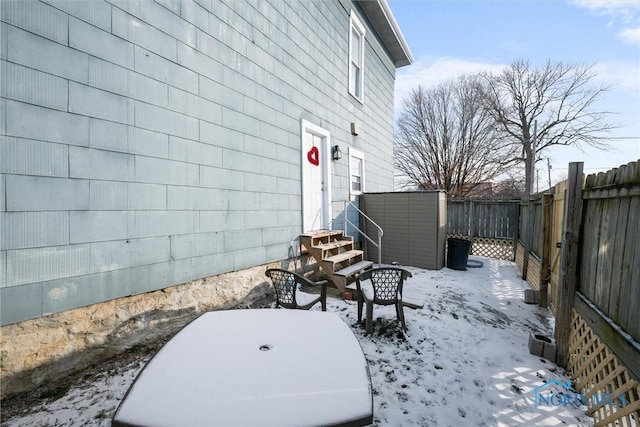 snow covered patio with a shed