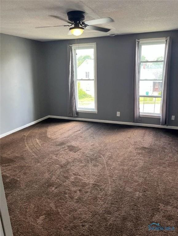 empty room featuring ceiling fan, carpet floors, and a textured ceiling