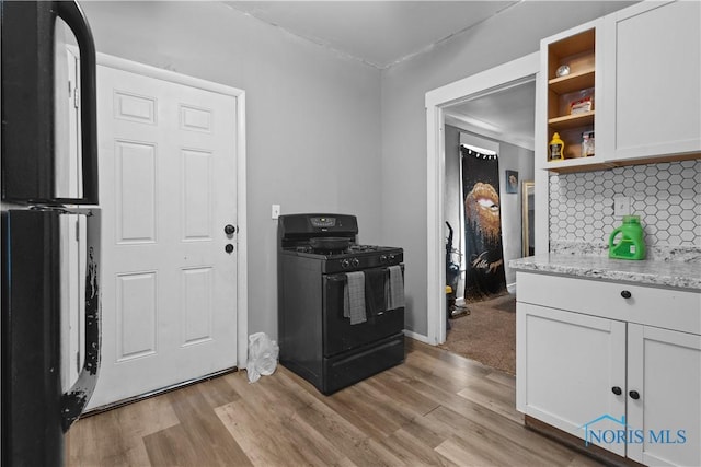 kitchen featuring white cabinetry, light wood-type flooring, backsplash, and gas stove