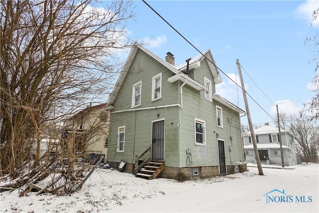 view of snow covered rear of property