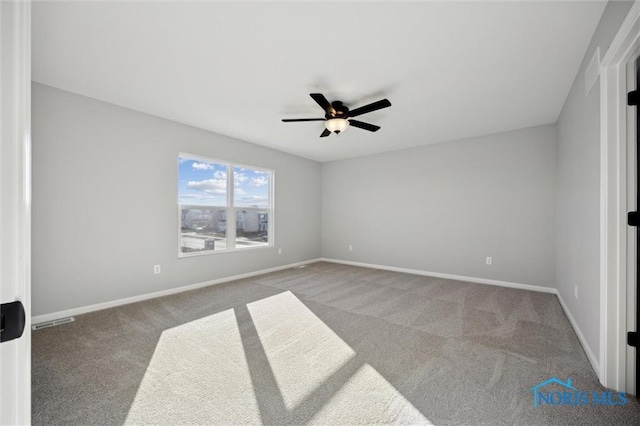 carpeted spare room featuring ceiling fan