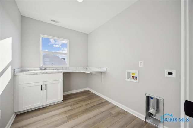 laundry area with sink, washer hookup, electric dryer hookup, cabinets, and light hardwood / wood-style flooring