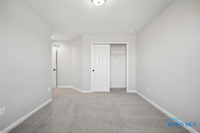 unfurnished bedroom with a closet and carpet