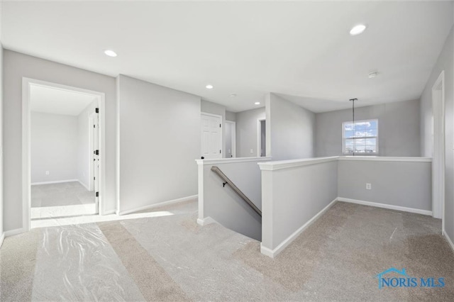 hallway featuring light colored carpet