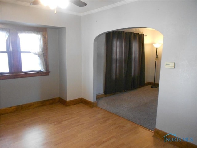 spare room with wood-type flooring, ceiling fan, and crown molding