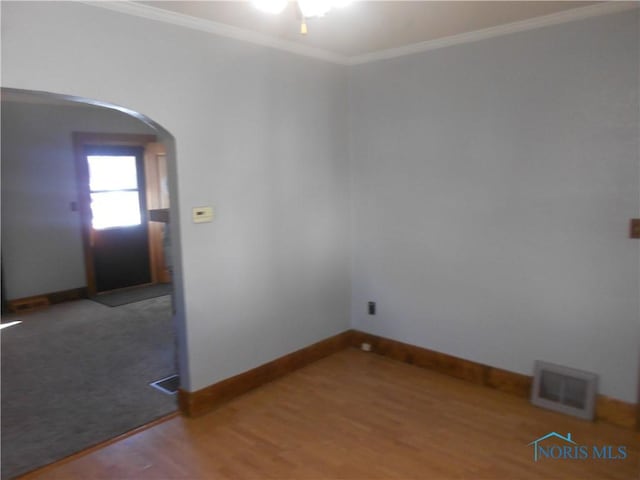 spare room with ornamental molding and dark wood-type flooring