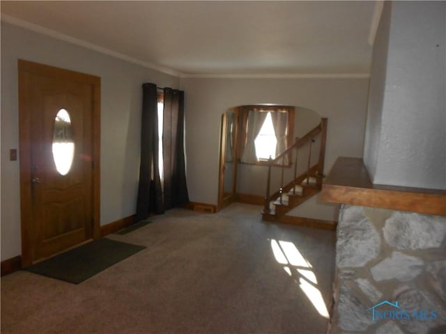 carpeted entrance foyer featuring crown molding