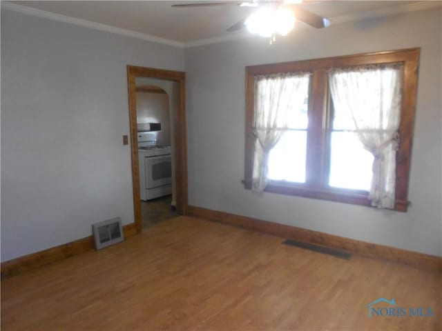 empty room featuring hardwood / wood-style flooring, ceiling fan, and ornamental molding