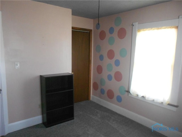 spare room featuring dark colored carpet