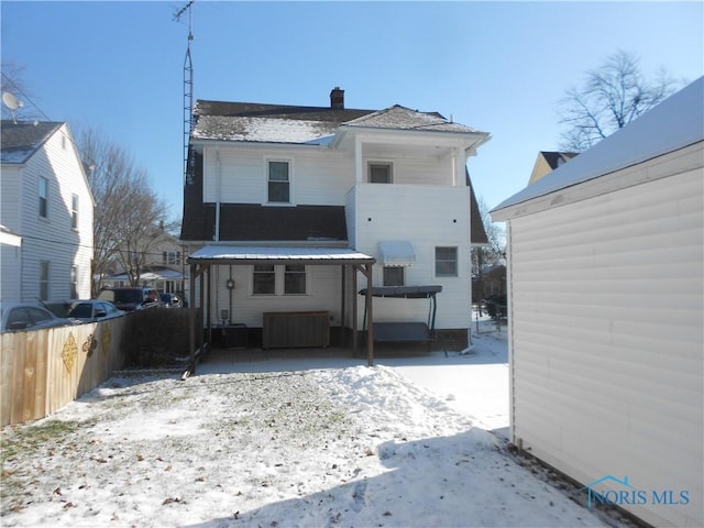 view of snow covered rear of property