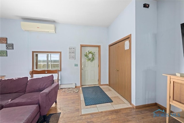 foyer featuring a baseboard radiator, light wood-type flooring, and an AC wall unit