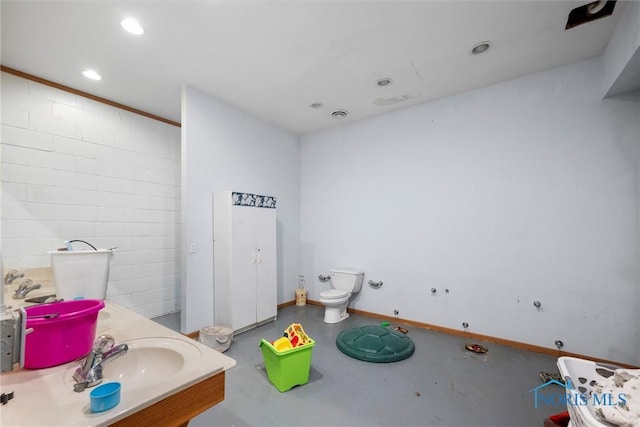 bathroom with vanity, concrete floors, and toilet