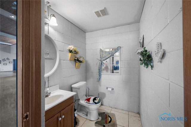 bathroom featuring tile patterned flooring, vanity, and toilet