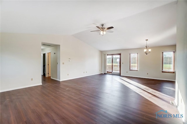 spare room with ceiling fan with notable chandelier, vaulted ceiling, a healthy amount of sunlight, and dark hardwood / wood-style floors