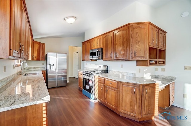 kitchen with vaulted ceiling, stainless steel appliances, light stone countertops, dark hardwood / wood-style flooring, and sink