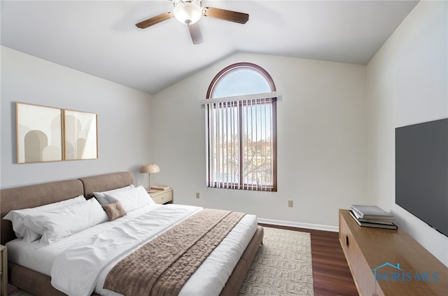 bedroom featuring vaulted ceiling, dark wood-type flooring, ceiling fan, and multiple windows