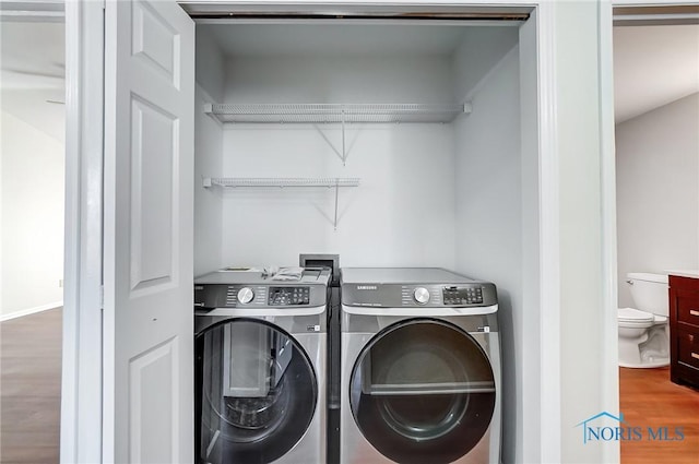 laundry room with washer and dryer and hardwood / wood-style floors