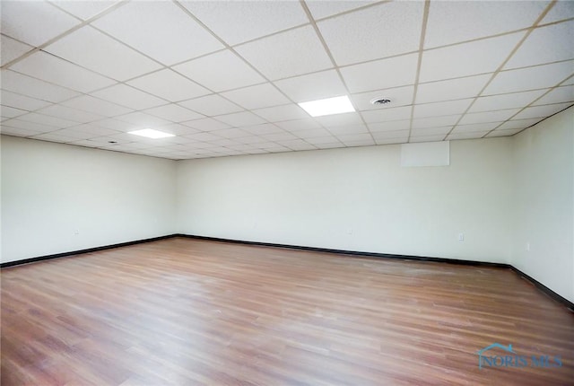 unfurnished room featuring a drop ceiling and hardwood / wood-style floors