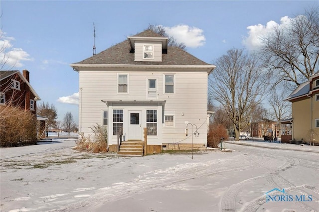 view of snow covered rear of property