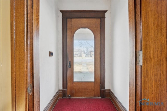 doorway with dark colored carpet