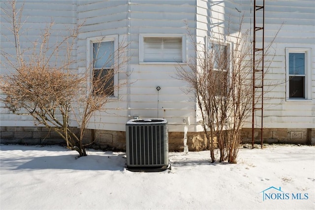 view of snow covered exterior featuring cooling unit