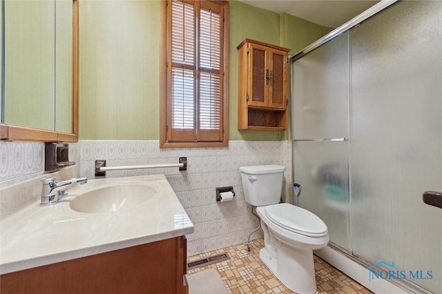 bathroom with vanity, tile walls, an enclosed shower, and toilet