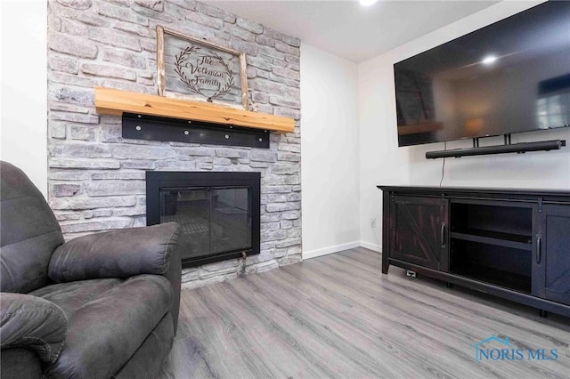 living room with light hardwood / wood-style floors and a fireplace