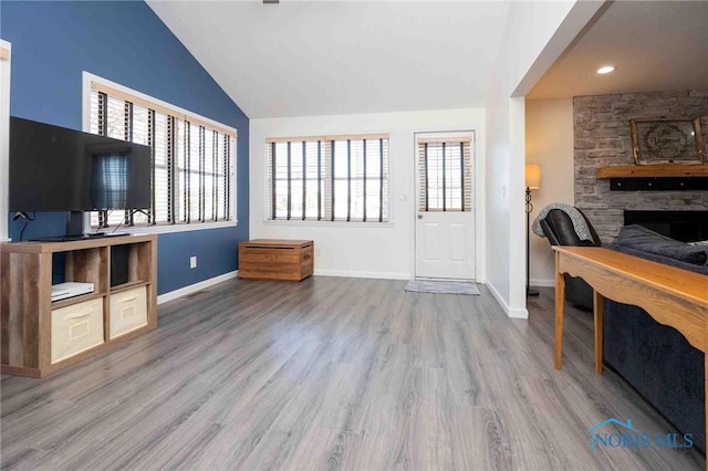 living room featuring lofted ceiling, a fireplace, and hardwood / wood-style flooring