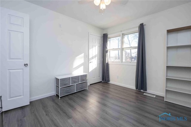 unfurnished bedroom with ceiling fan and dark hardwood / wood-style floors