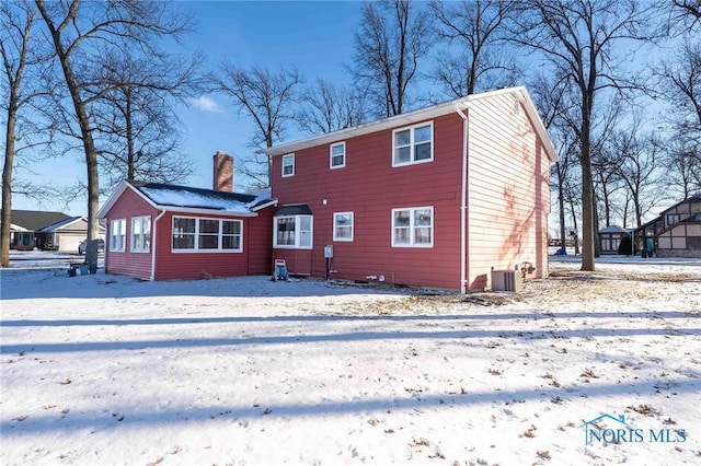 snow covered property with central AC