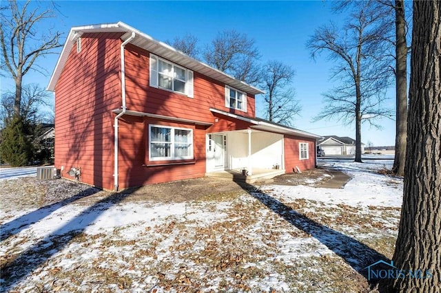 snow covered property with central air condition unit