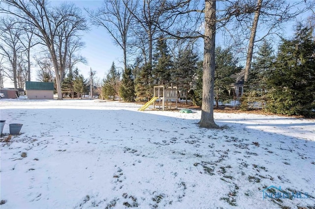 yard covered in snow with a playground