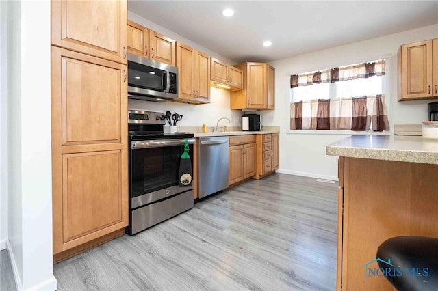 kitchen featuring light hardwood / wood-style floors, sink, light brown cabinetry, and stainless steel appliances