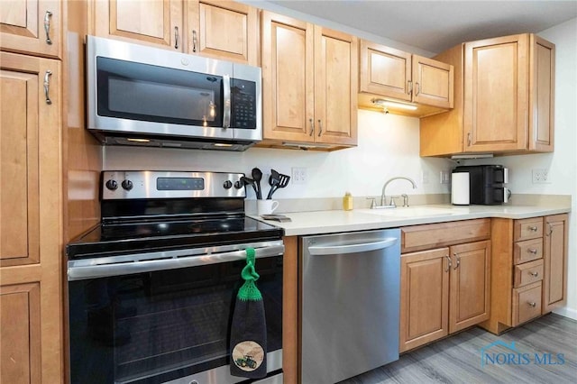 kitchen featuring sink, light brown cabinets, stainless steel appliances, and light hardwood / wood-style floors