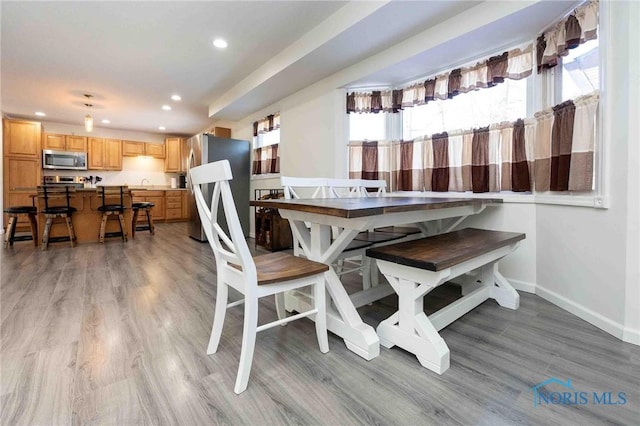 dining space with light hardwood / wood-style floors and sink