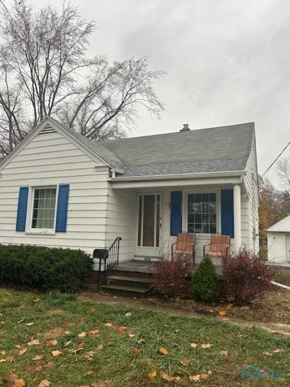 bungalow-style house with a front yard and covered porch